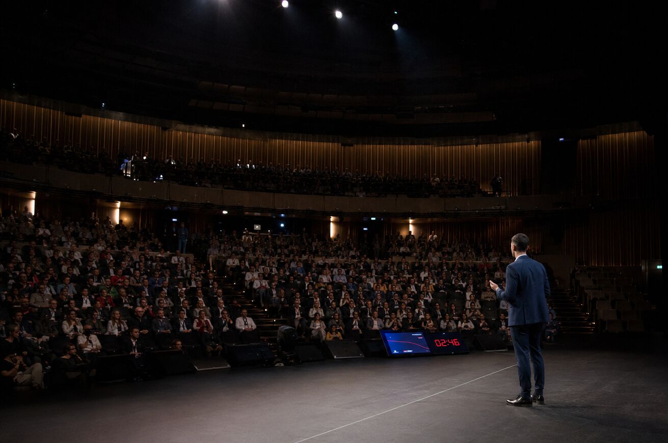 Luca Dal Zilio speaking to a large auditorium audience